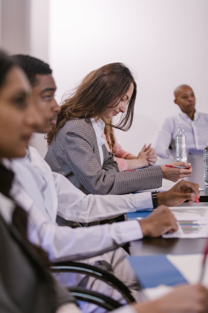 Crafting Captivating Headlines: Your awesome post title goes here A diverse group of professionals engaged in a focused and attentive business meeting in a conference room.